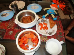 Un petit-déjeuner indien: du thé, de la mangue et des toasts à la pomme de terre.